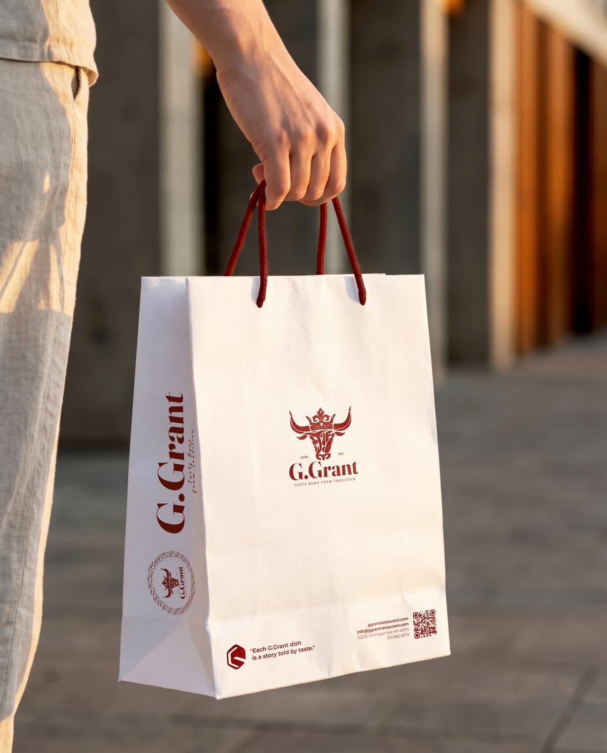 A guest carrying a white G.Grant bag with red rope handles