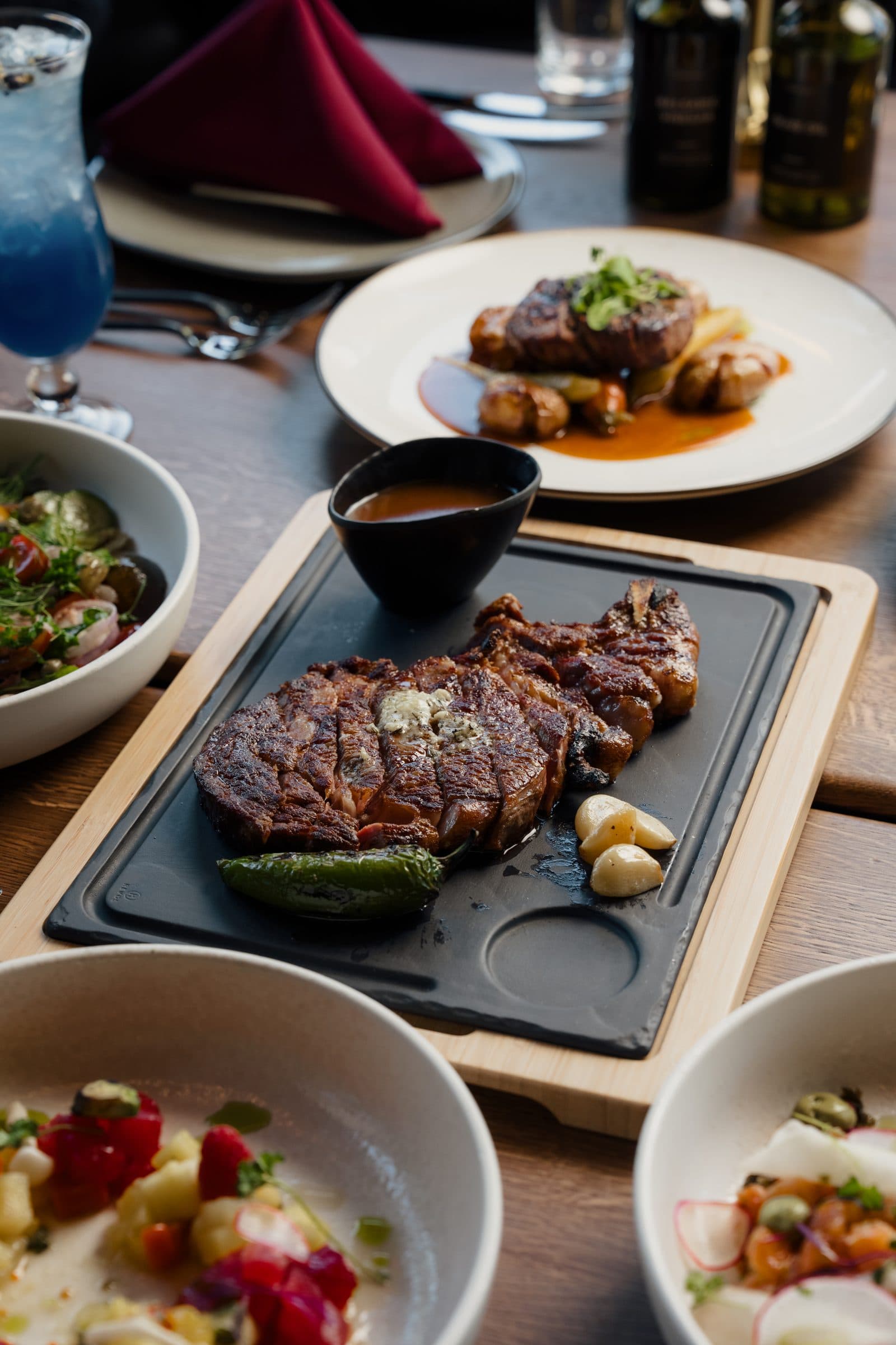 A table at G.Grant with dry-aged ribeye, salads and sides to share